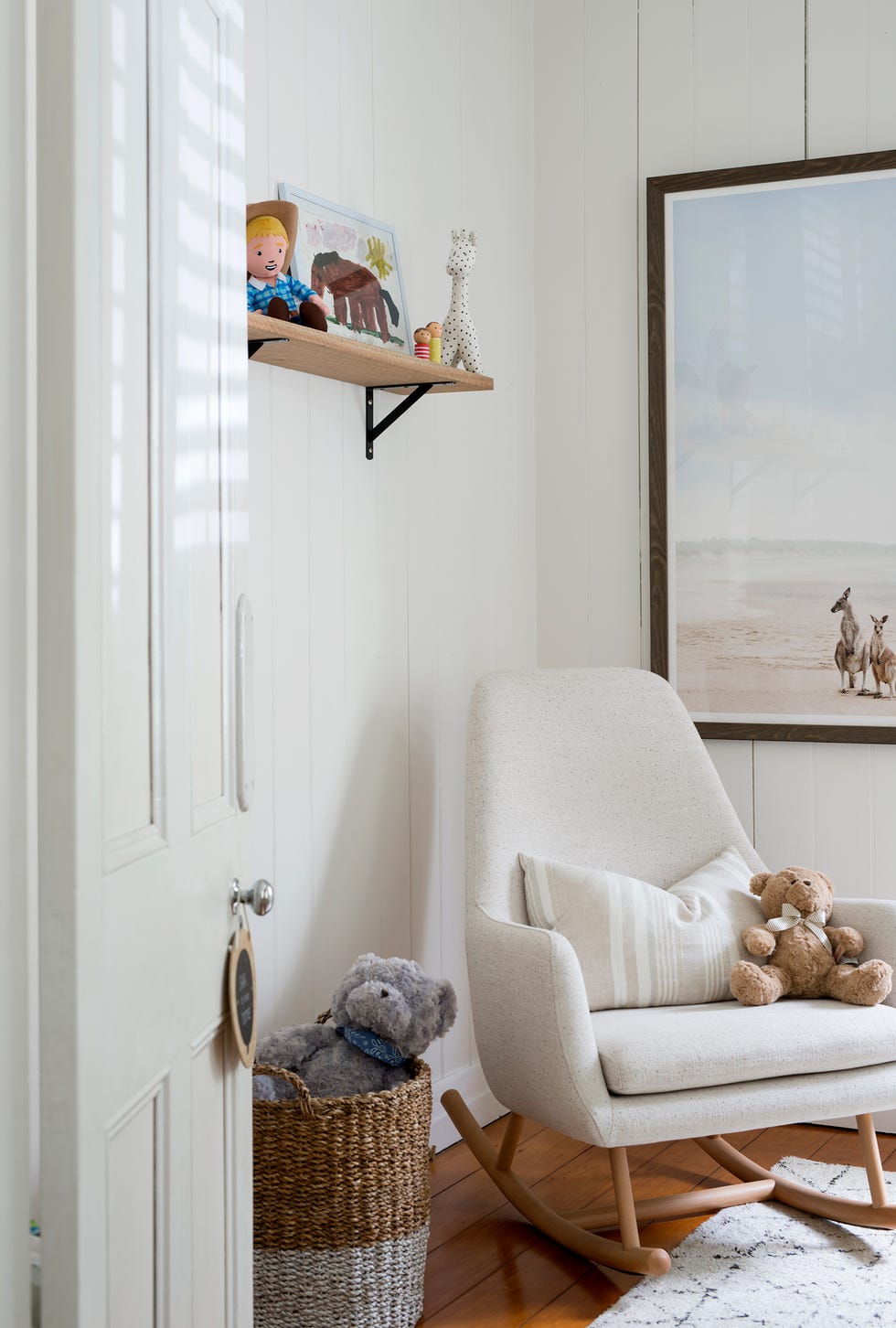 habitación de bebé de estilo rústico en blanco con una mecedora de diseño nórdico