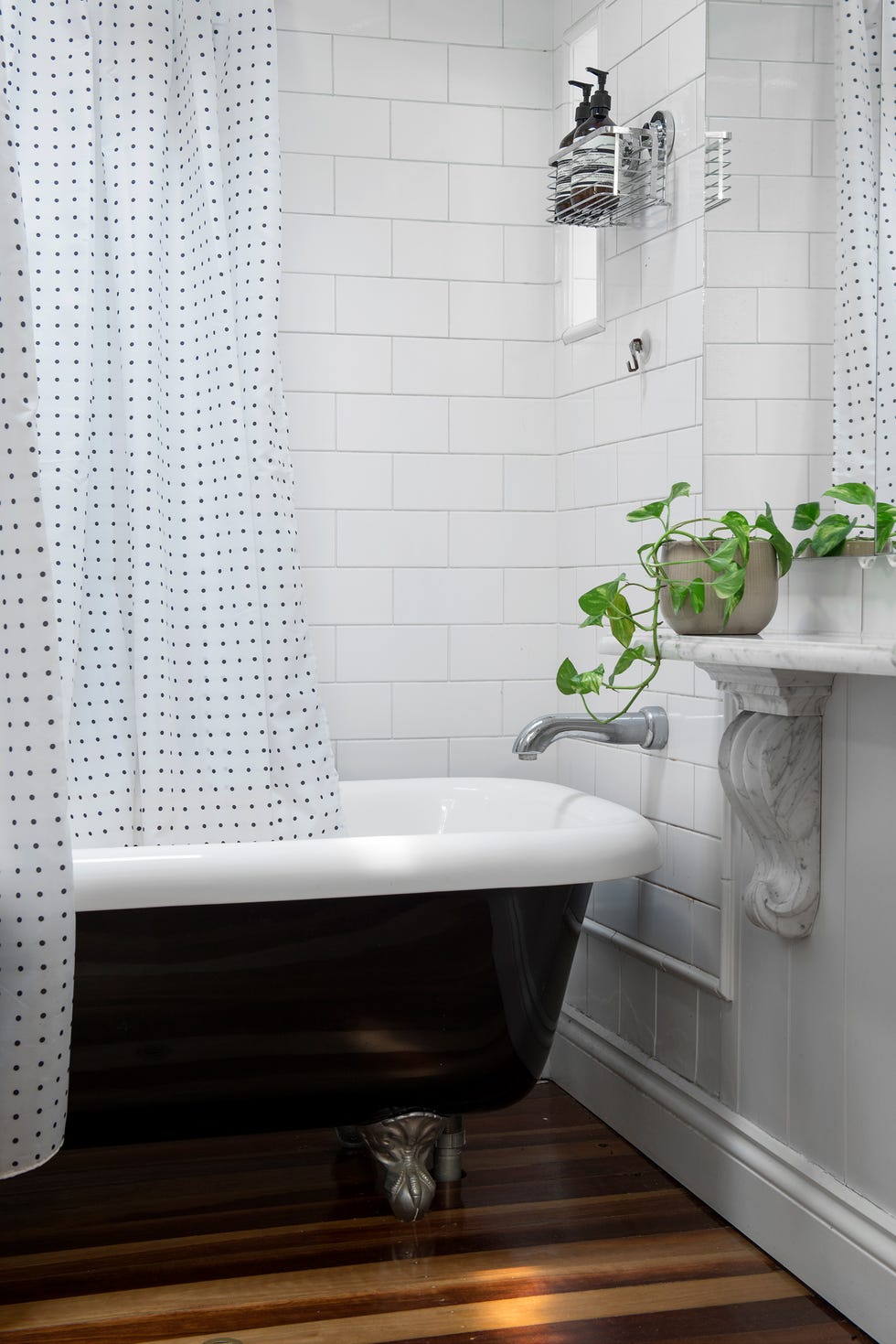 baño vintage con bañera con patas y azulejos tipo metro blancos