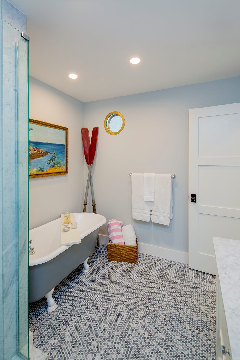 baño con bañera clásica y suelo de azulejos en mosaico
