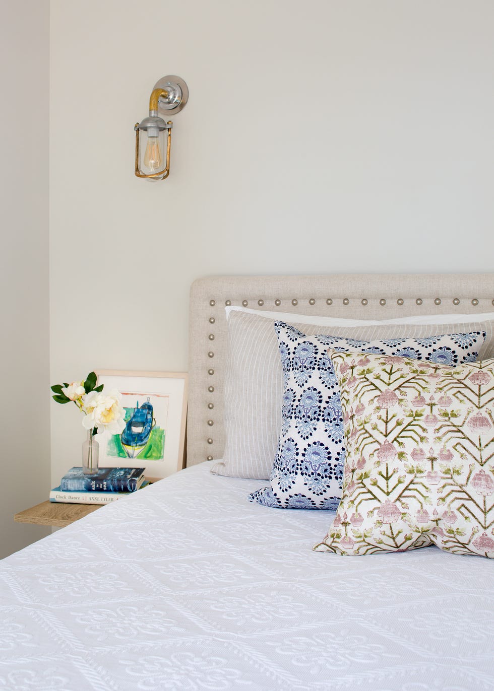 cama con cabecero tapizado en beige con remaches