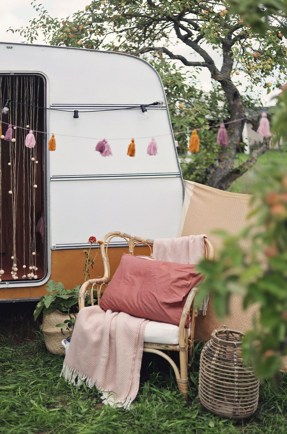 autocaravana vintage en el jardín con sillón de mimbre