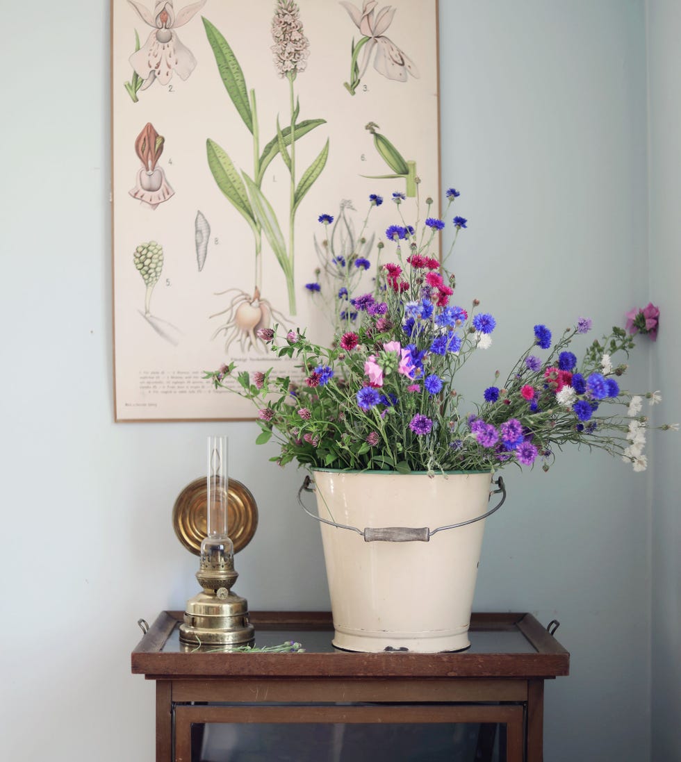 caldero vintage de color crema como macetero con flores
