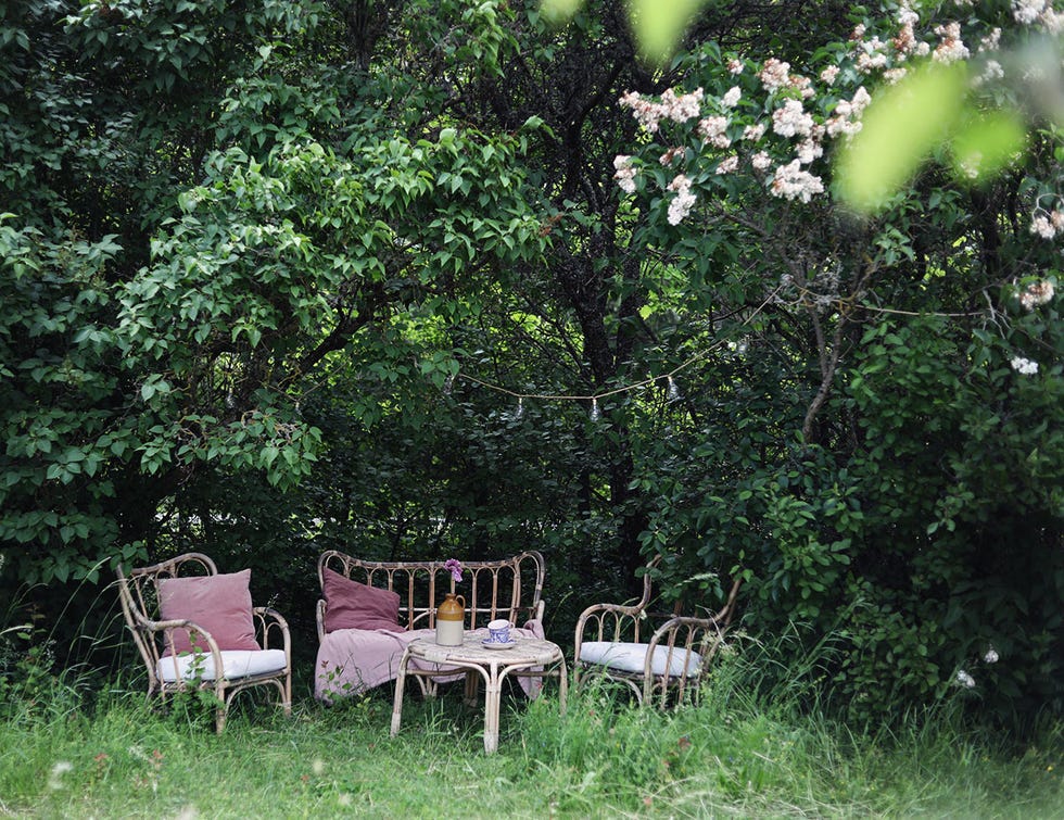 zona de estar con muebles de mimbre en el jardín