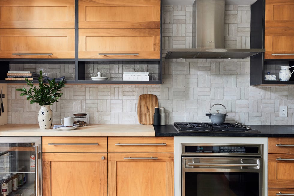 cocina con armarios de madera y encimera de mármol negro y madera