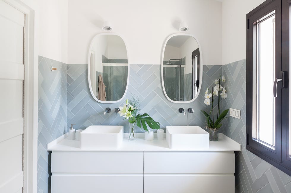 baño con mueble blanco, dos lavabos y azulejos en espiga azules