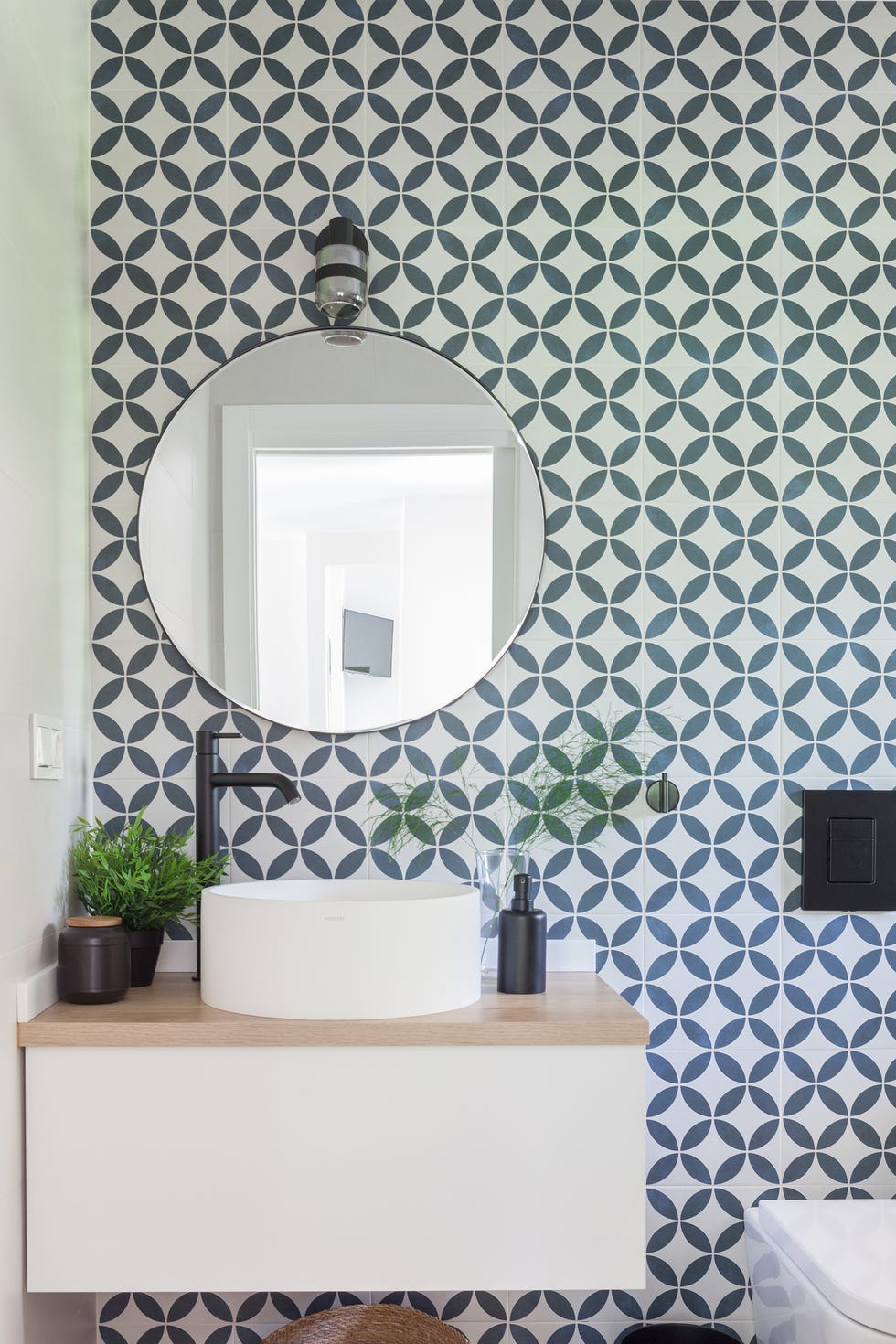baño con mueble volado blanco, lavabo exento y azulejos tipo mosaico en blanco y azul
