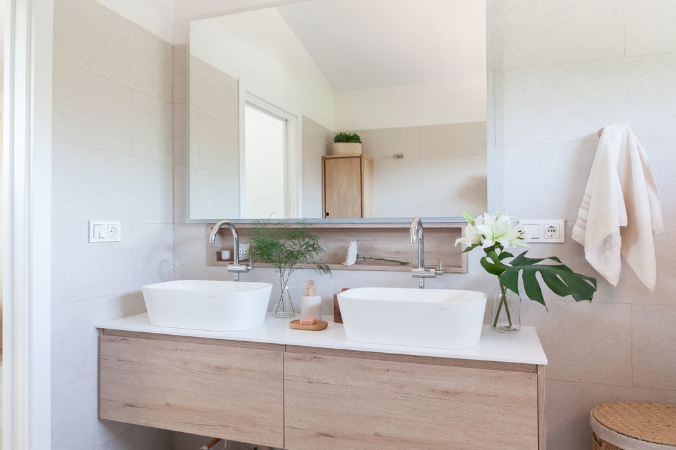 baño con mueble de madera y dos lavabos exentos