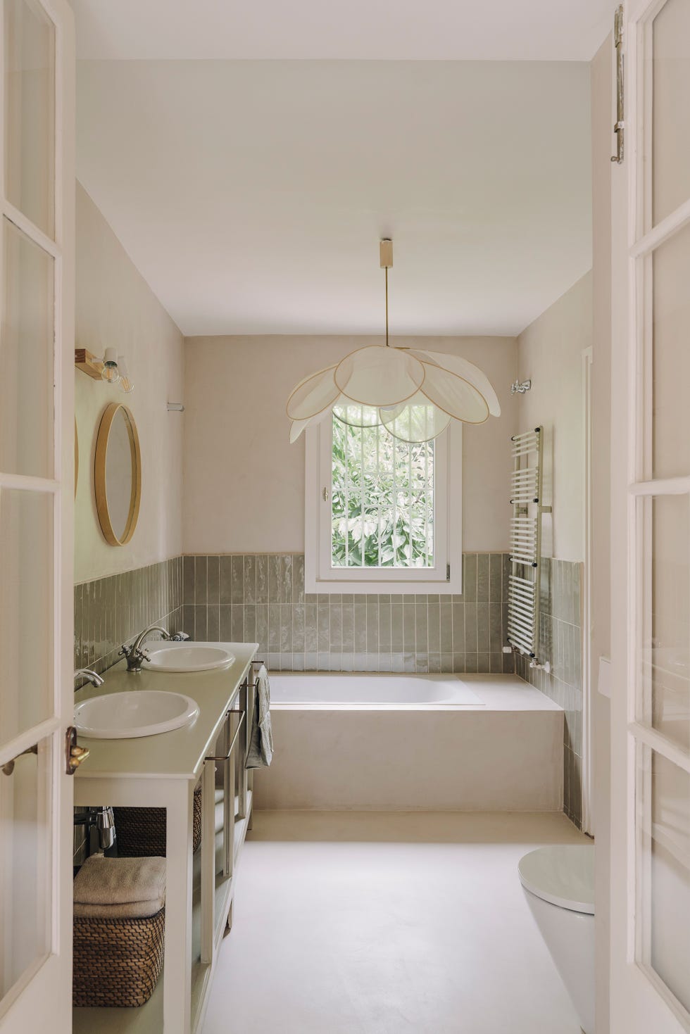 baño rústico con mueble antiguo con dos lavabos, azulejos verdes a media pared y lámpara pétalo