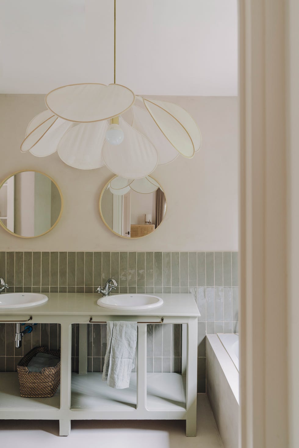baño rústico con mueble antiguo con dos lavabos, azulejos verdes a media pared y lámpara pétalo