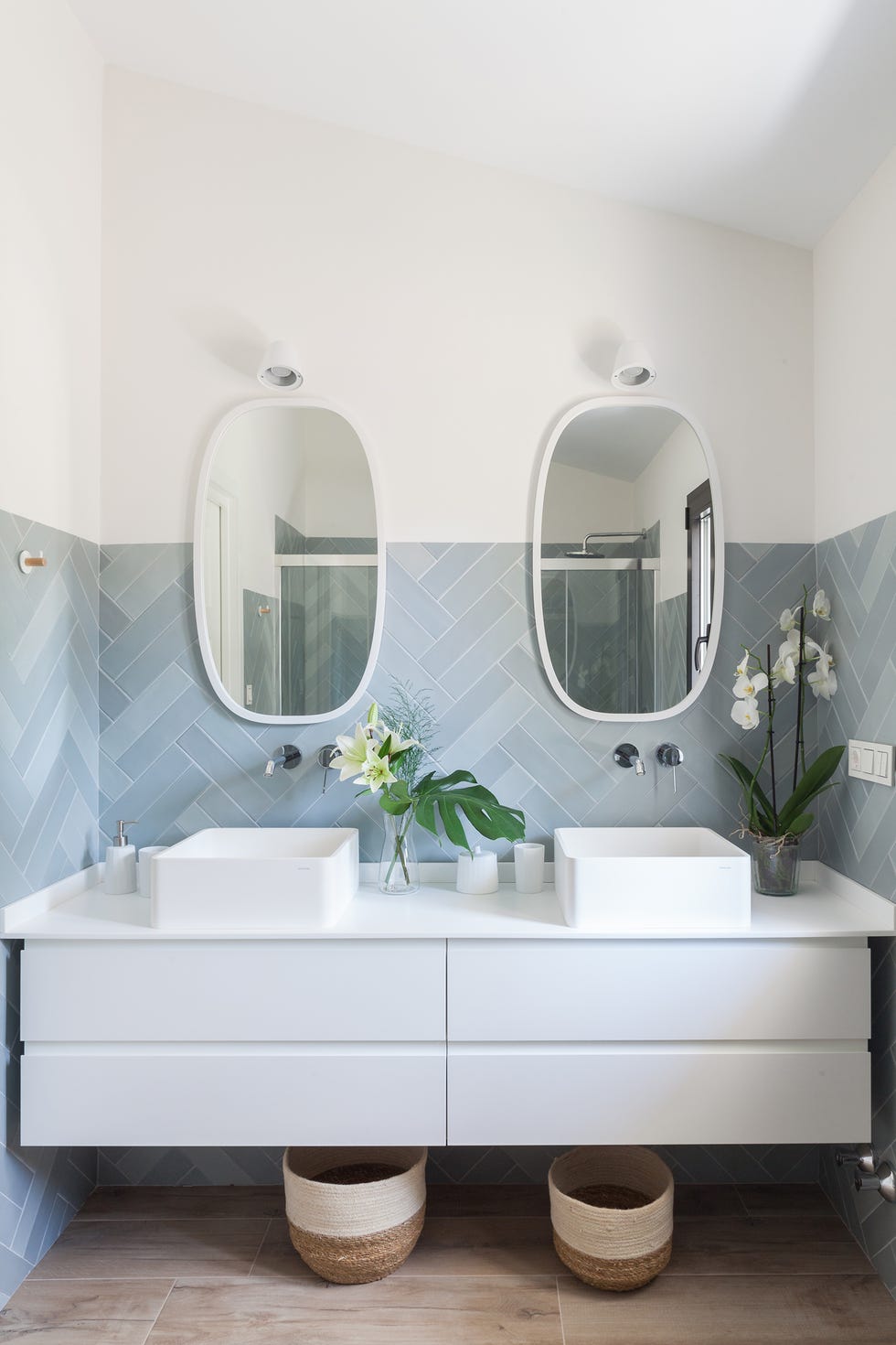 baño con mueble blanco, dos lavabos y azulejos en espiga azules