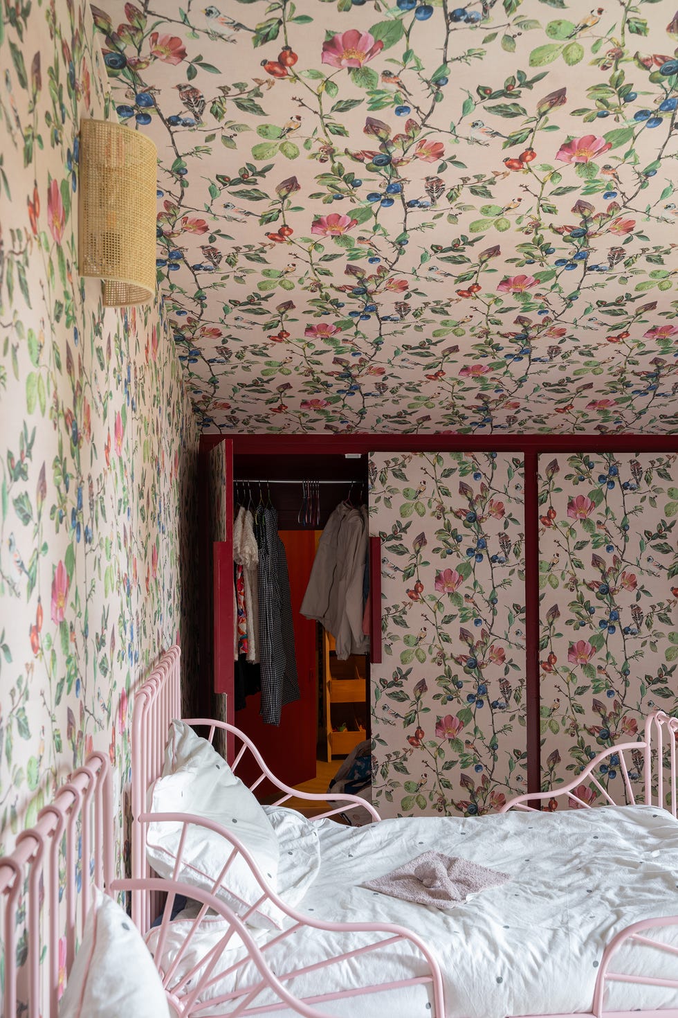 habitación infantil con papel pintado floral en techo y paredes