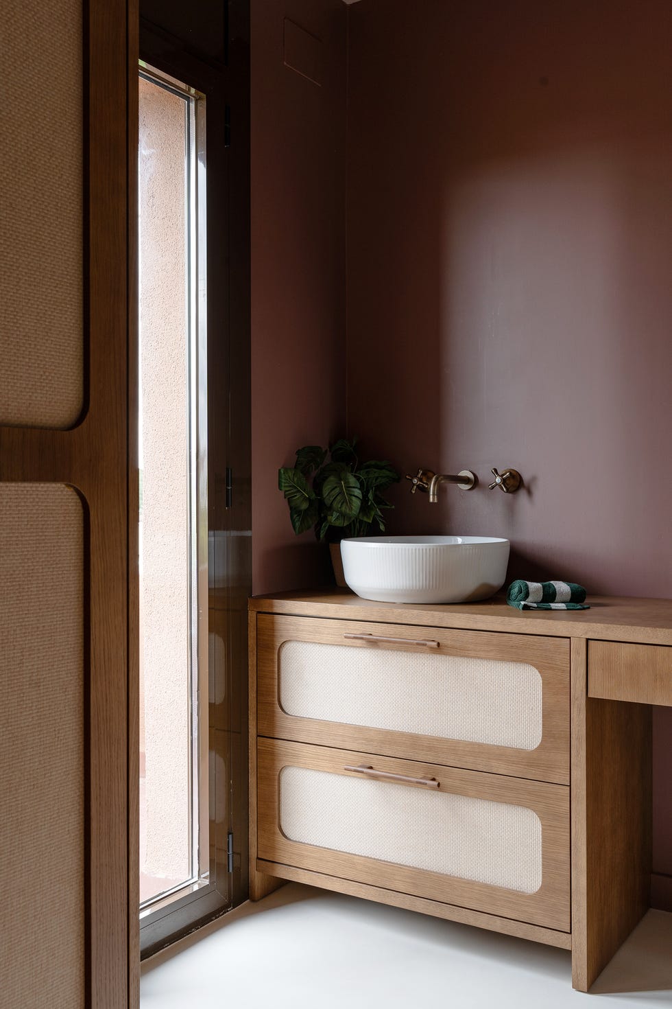 mueble de baño de madera con frentes de rejilla y lavabo exento