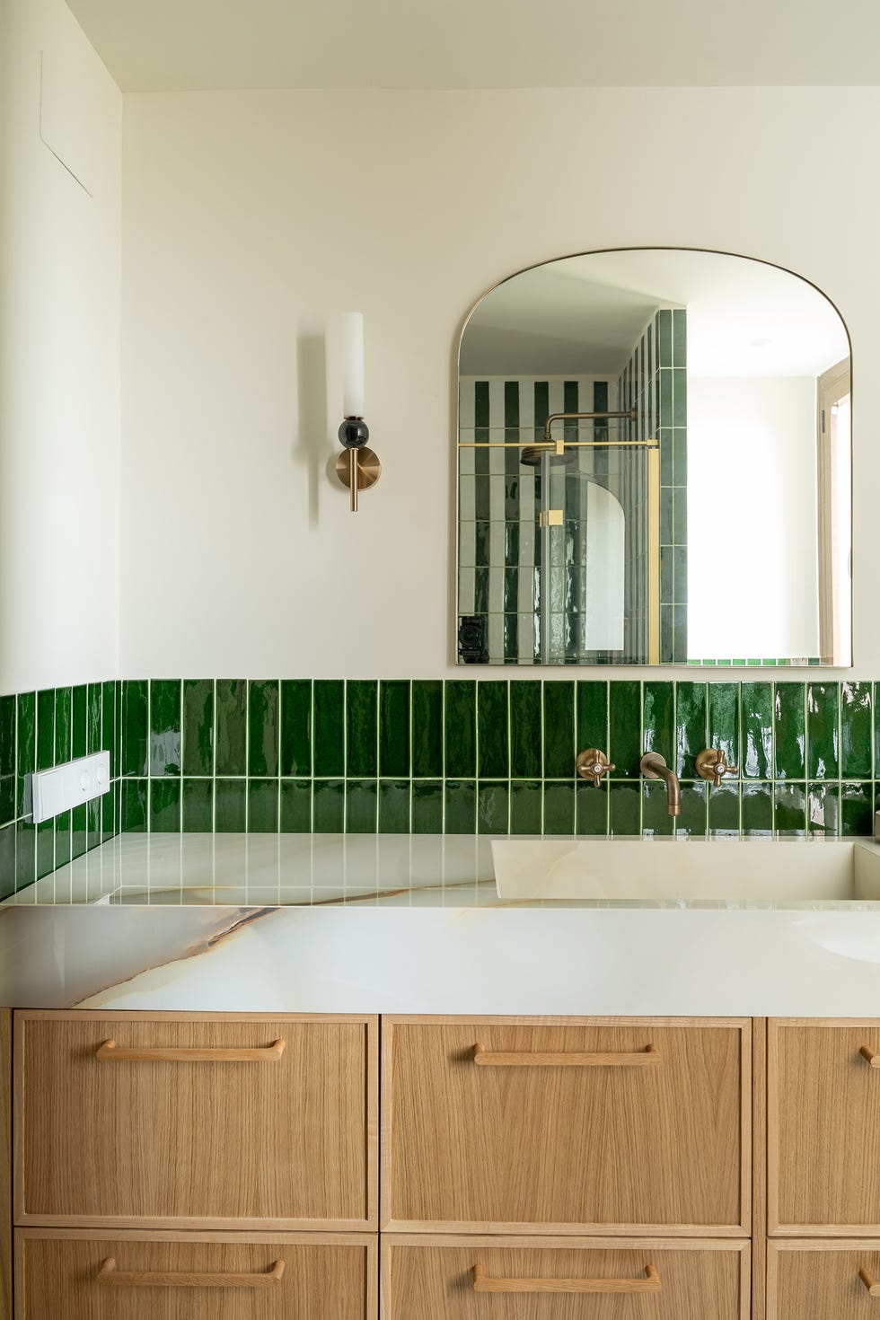 baño con mueble de madera y azulejos verdes