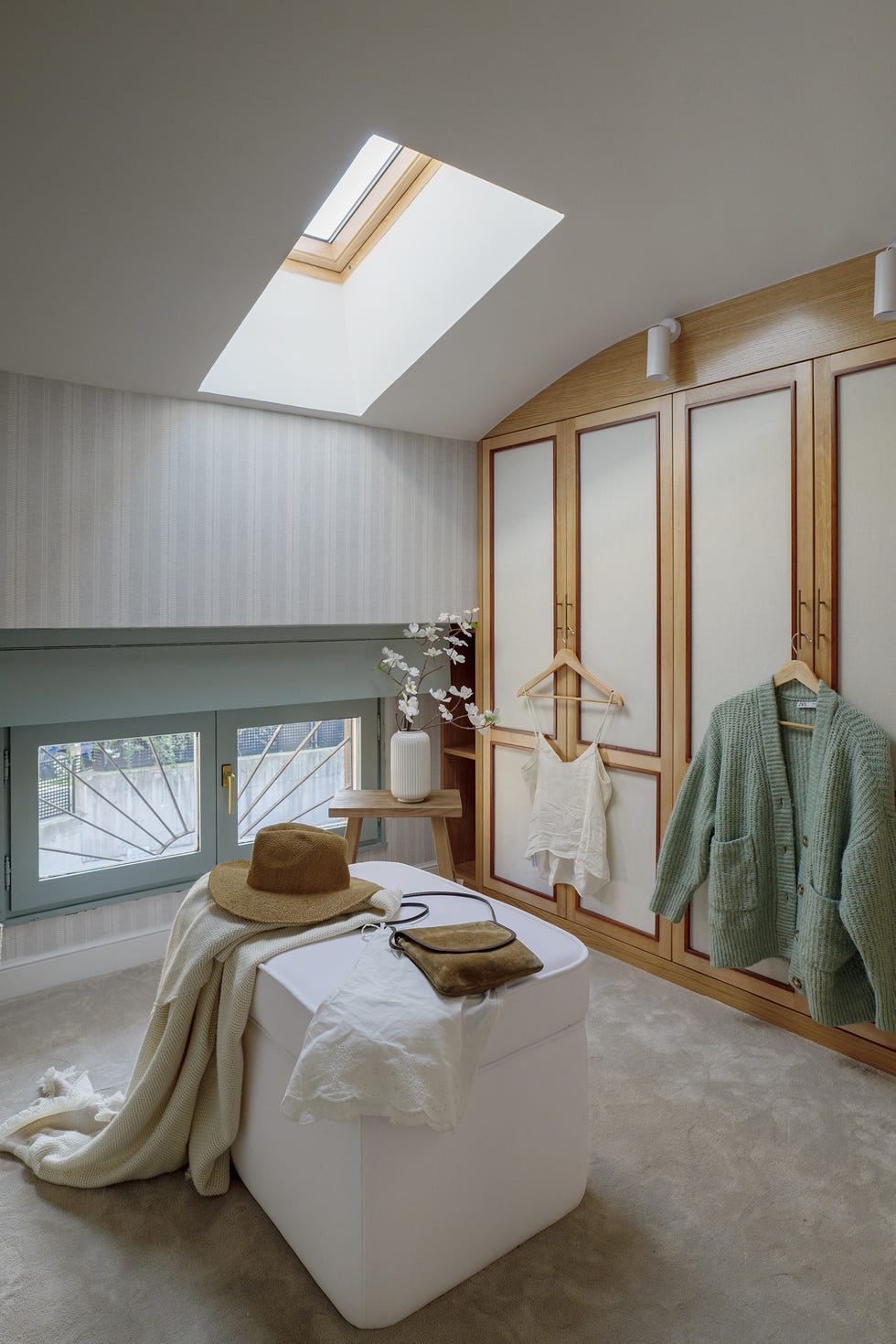 vestidor con armarios de madera y puf blanco