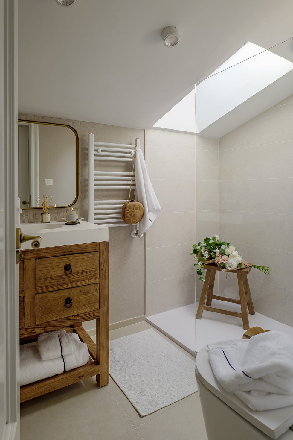 baño abuhardillado con mueble rústico de madera y ducha