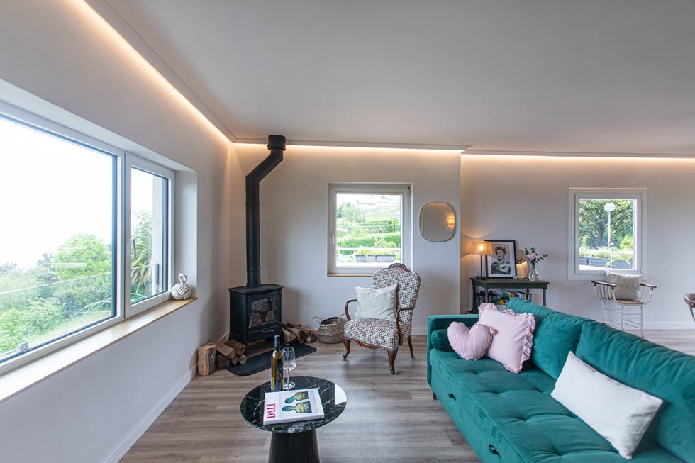 salón con chimenea y sofá de terciopelo verde