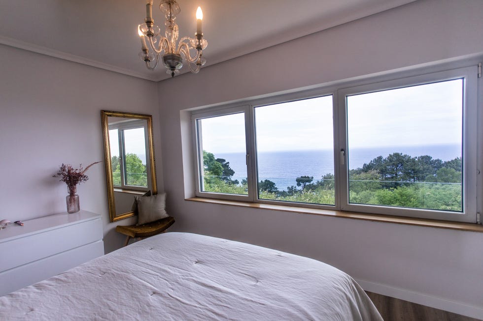 dormitorio con ventanal con vistas al mar