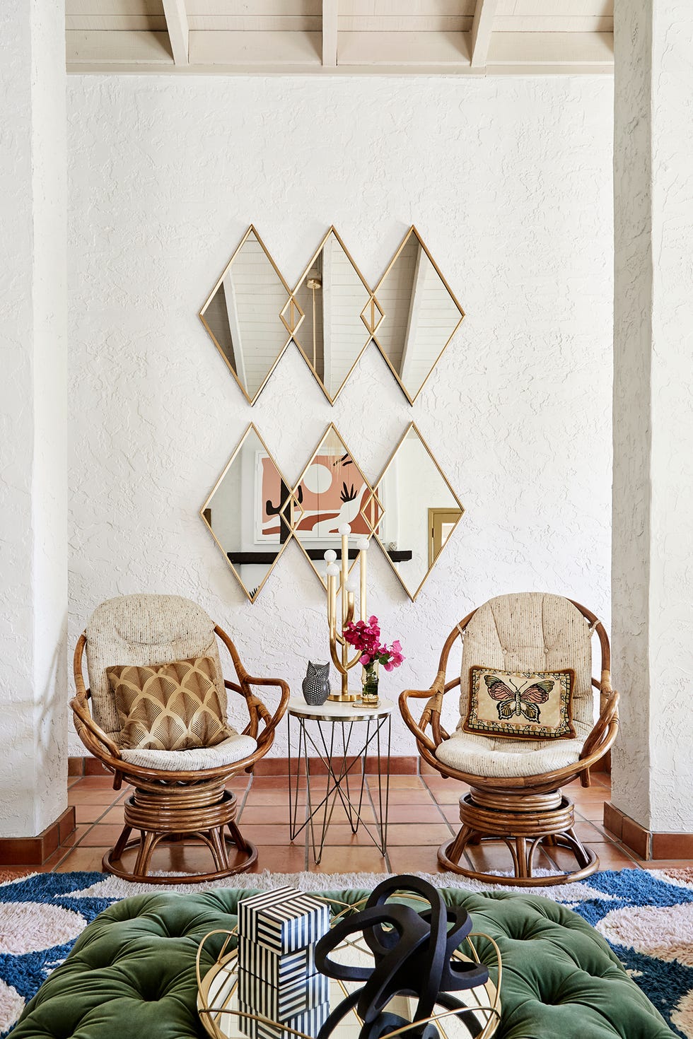 butacas de madera y espejos de pared con forma de rombo y estructura dorada