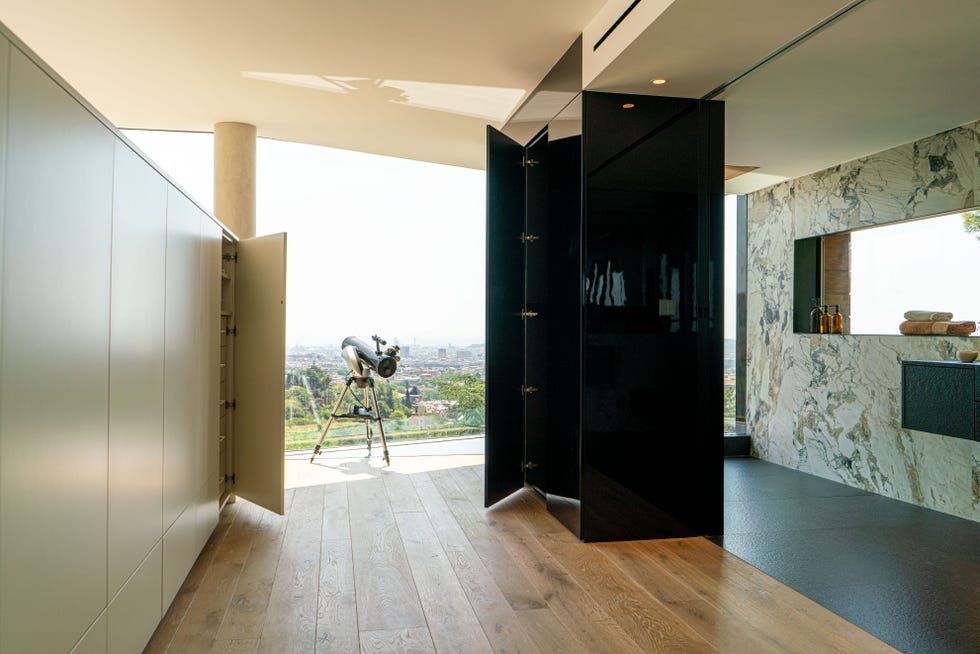 vestidor y baño en suite con pared de mármol