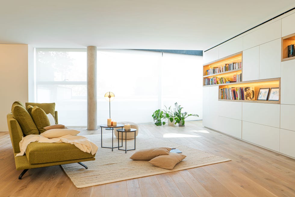 salón con sofá verde y estantería blanca a medida con diseño moderno