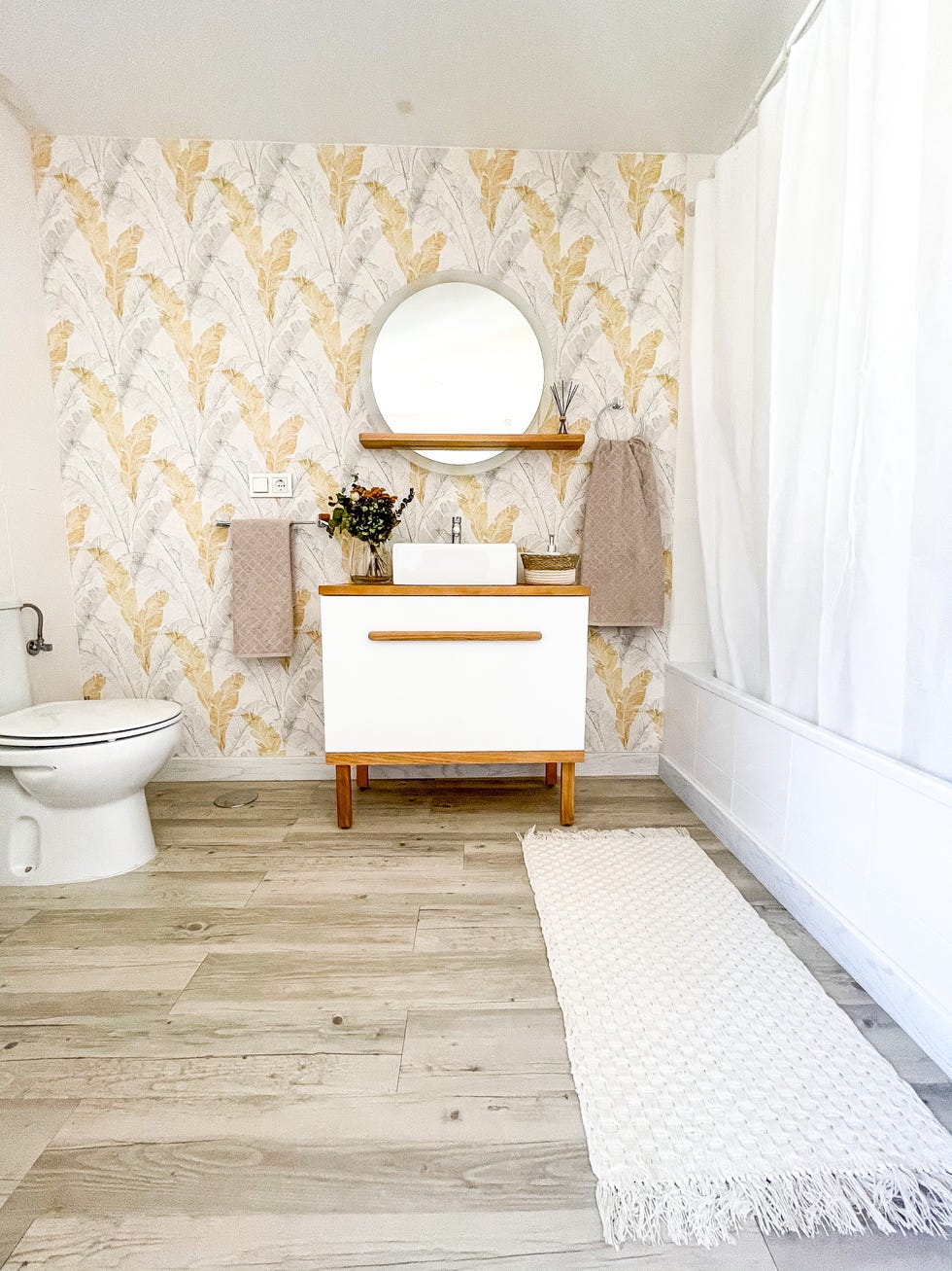 baño decorado con papel pintado botánico en tonos grises y ocres