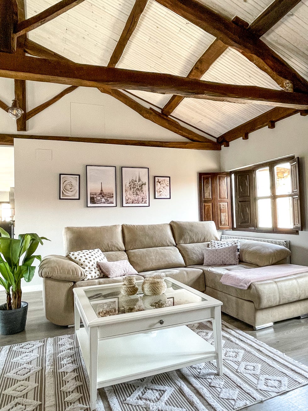 salón de estilo nórdicorústico con vigas de madera vistas