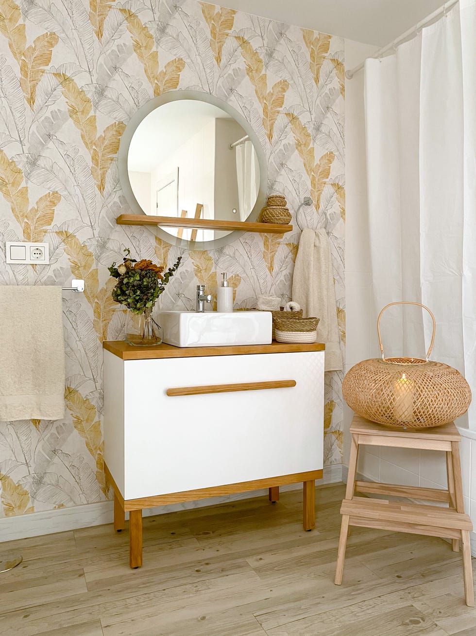 baño decorado con papel pintado botánico en tonos grises y ocres