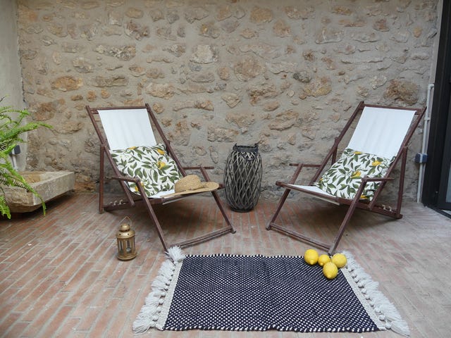 patio rústico con paredes de piedra y dos hamacas