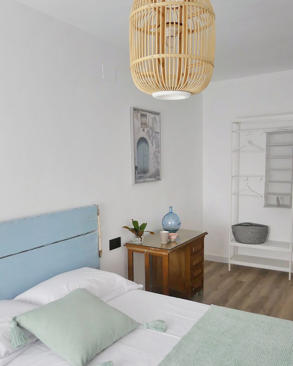 dormitorio rústico con cabecero de lamas azul y muebles recuperados