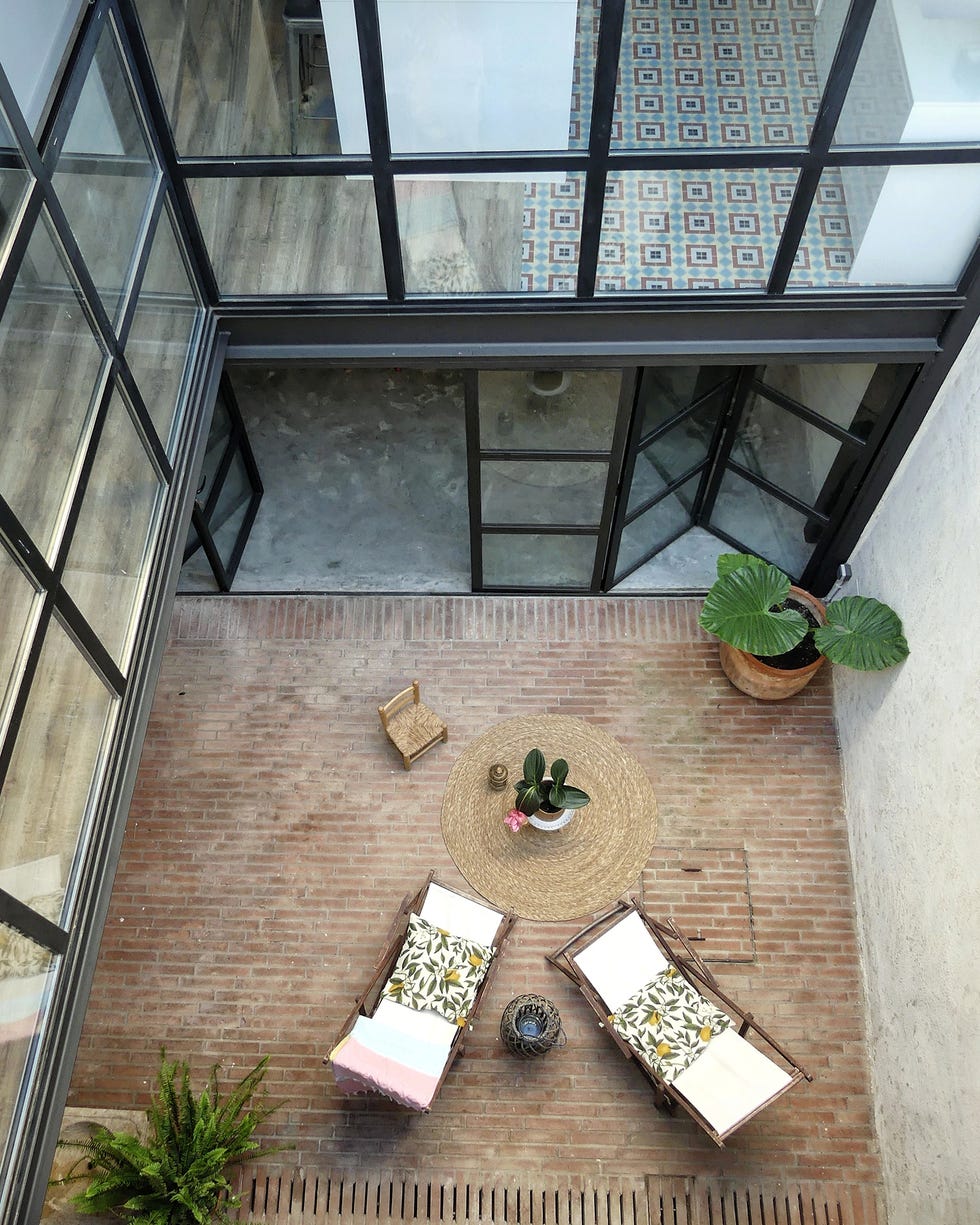 patio interior con hamacas y suelo de ladrillo visto