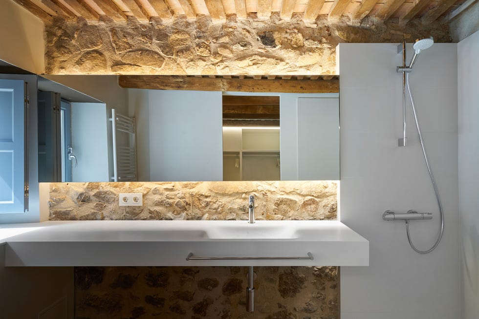 baño rústico con ducha y paredes de piedra vista