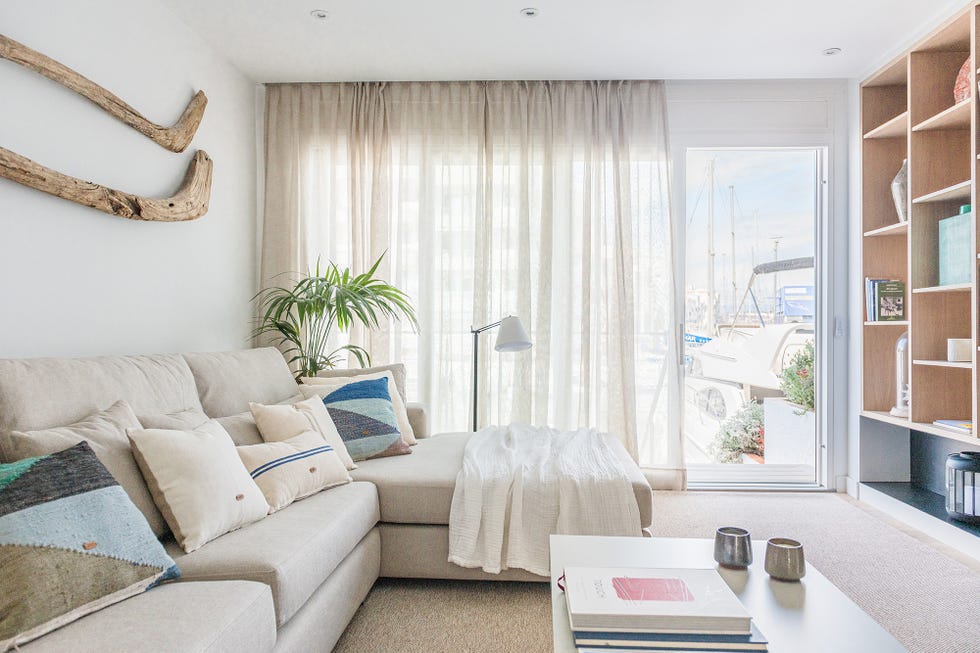 salón decorado en tonos neutros con sofá con chaise longue y estantería de madera