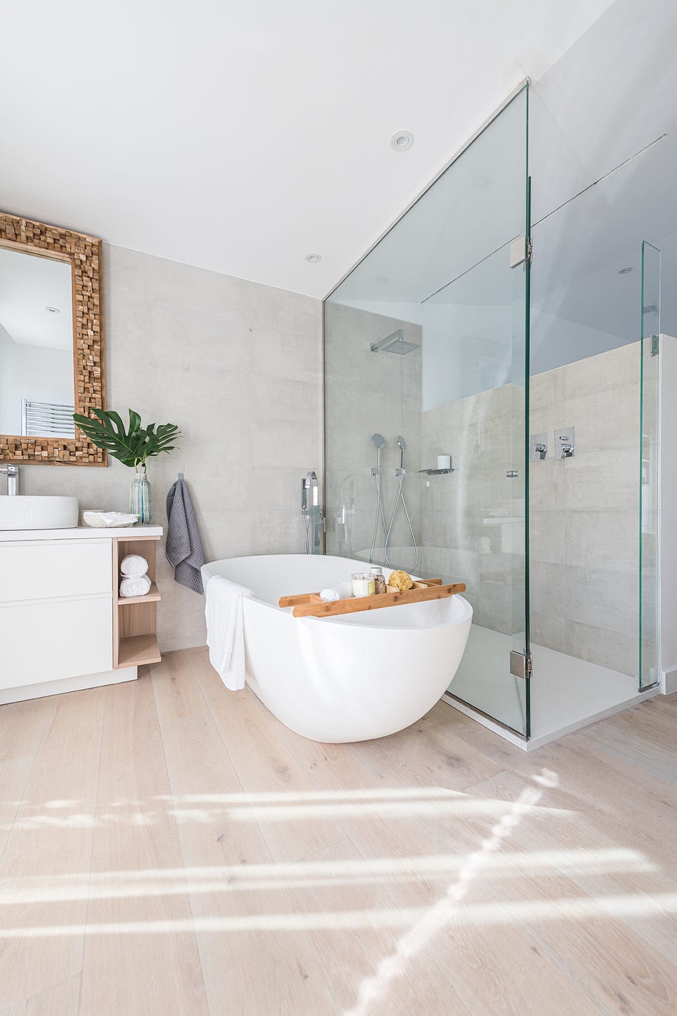 bañera exenta blanca y ducha de obra sobre suelo de tarima