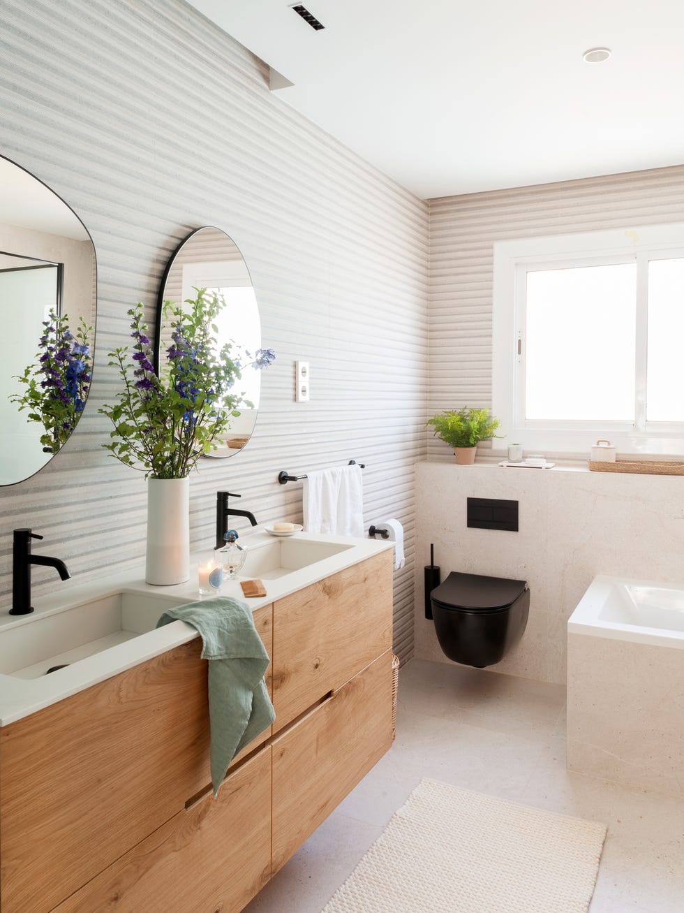 baño con mueble doble de madera y dos espejos redondos