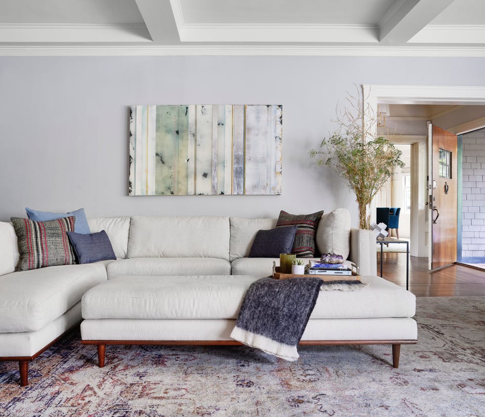 sofá con chaise longue y reposapiés en color beige