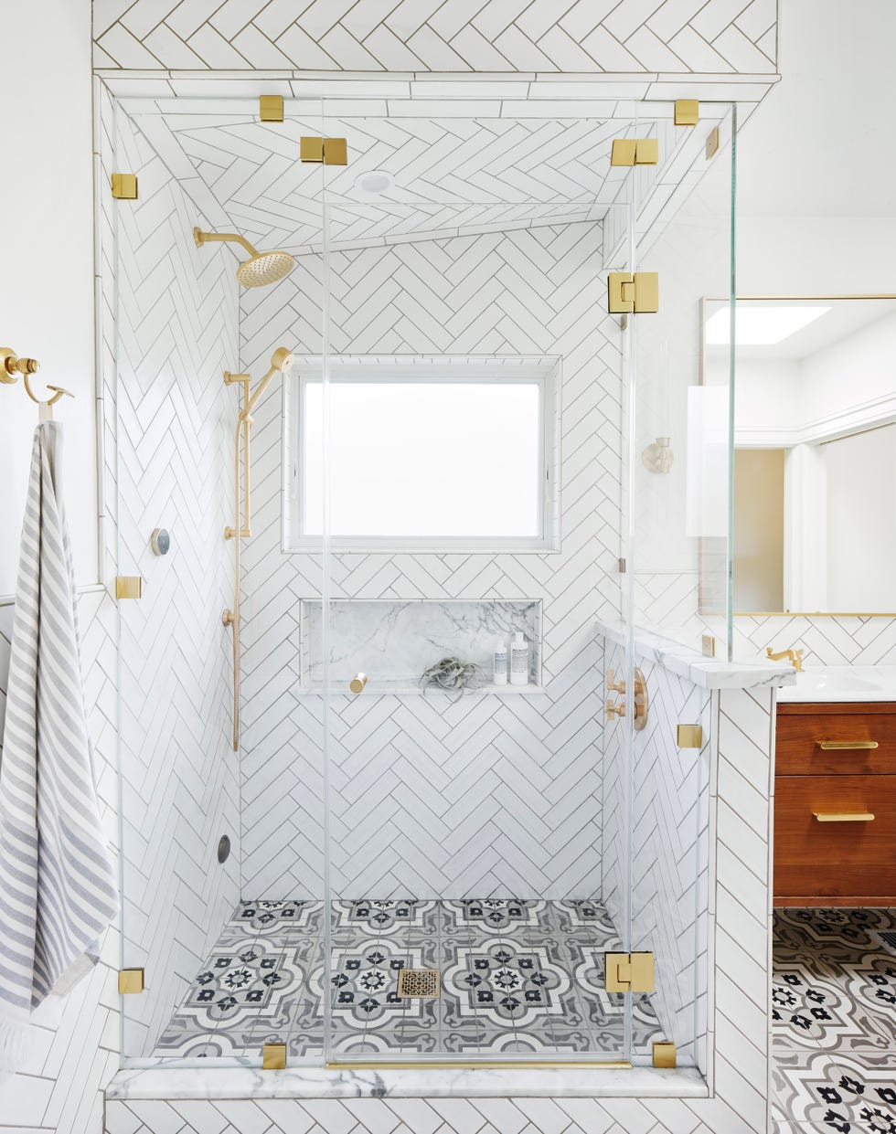 baño con ducha revestida con azulejos blancos en espiga y suelo hidráulico