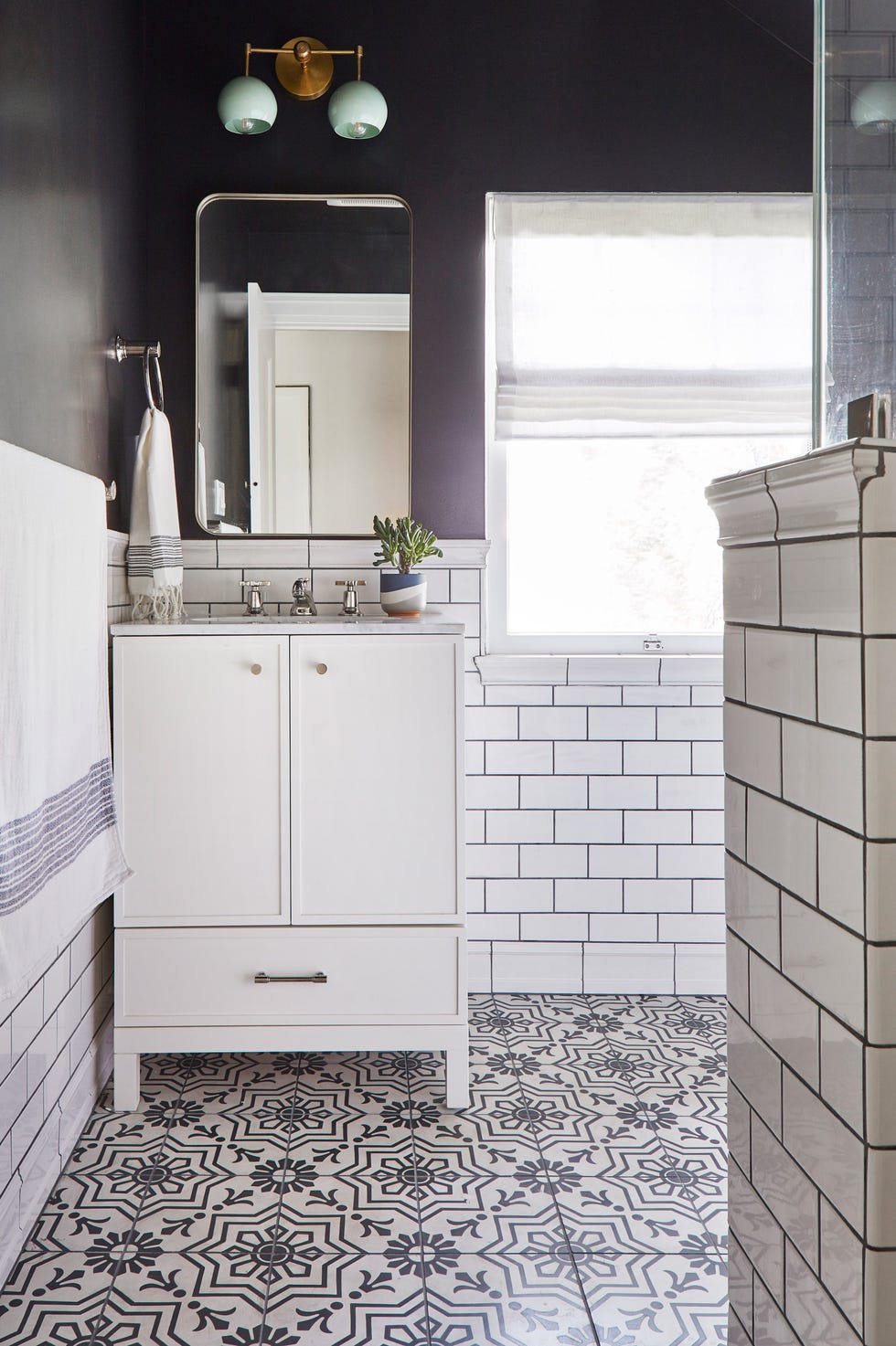 baño de estilo retro con azulejos blancos tipo metro y baldosa hidráulica