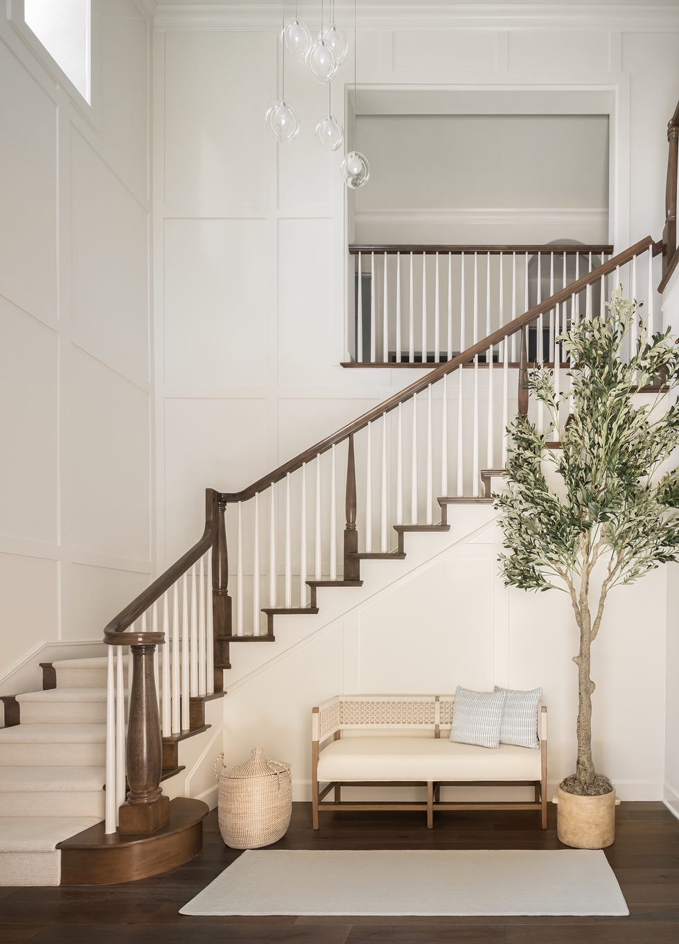 recibidor con sofá, árbol de interior y escalera