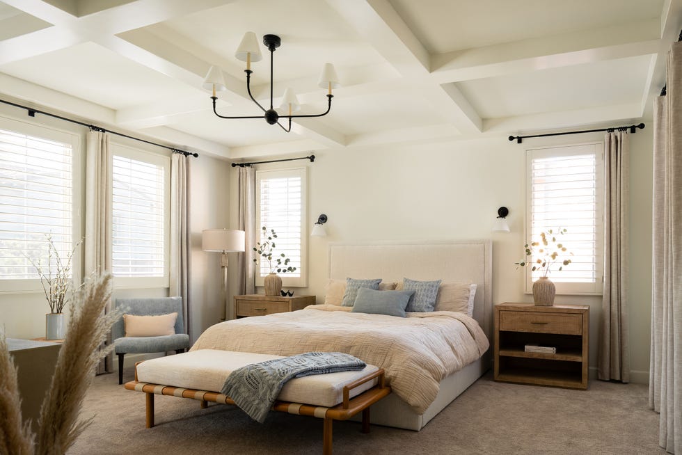 dormitorio con cama tapizada en beige y banco a los pies