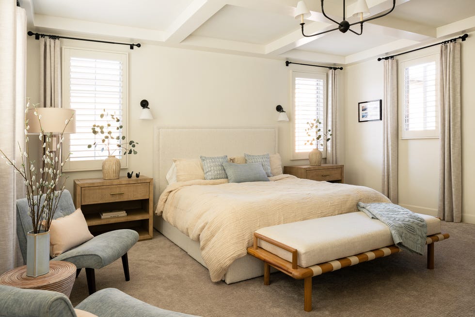 cama tapizada en beige y banco a los pies