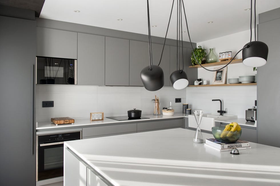 cocina de diseño moderno decorada en gris con isla central de mármol blanco