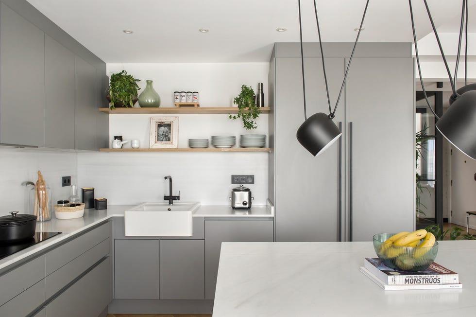cocina de diseño moderno decorada en gris con isla central de mármol blanco