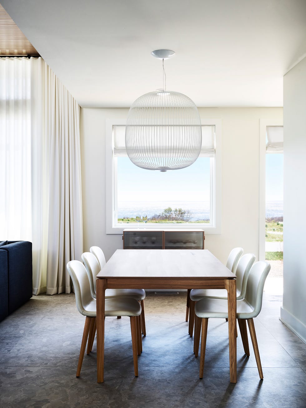comedor de diseño contemporáneo con mesa de madera y sillas blancas