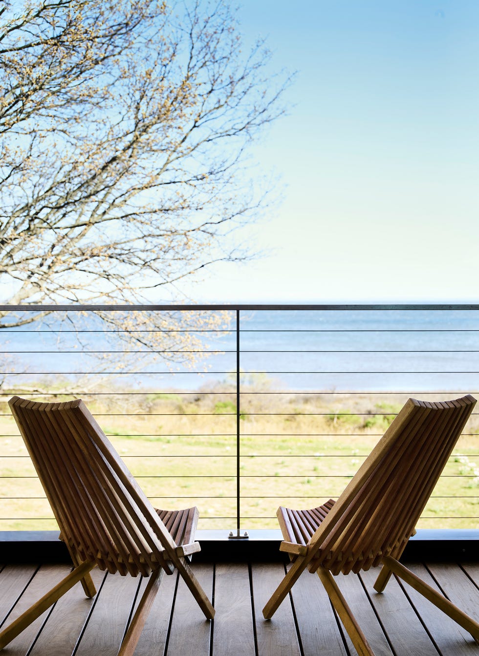 terraza con tarima de madera y dos sillas de exterior