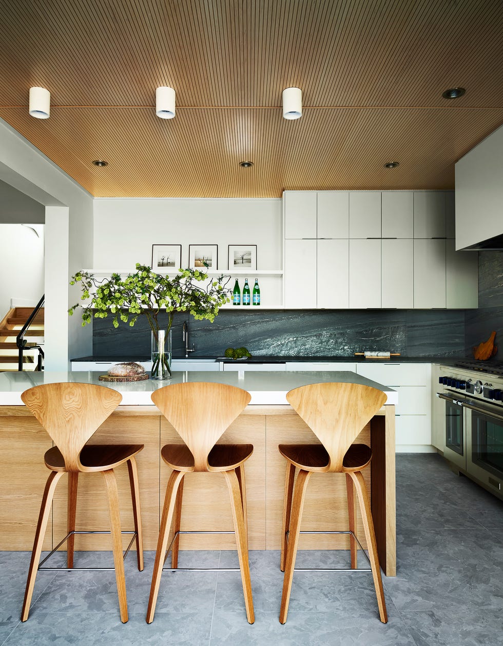 cocina blanca con isla central y frente de piedra negra