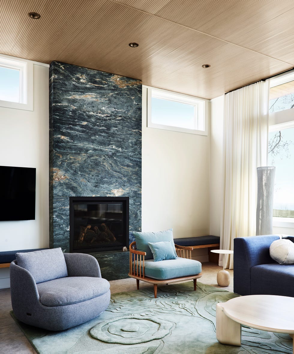 salón de diseño contemporáneo con butacas redondeadas y chimenea revestida en piedra