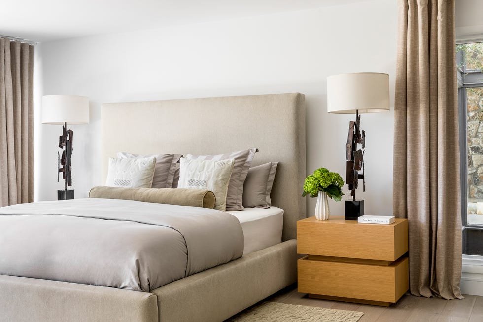 dormitorio con cama beige y mesitas de madera