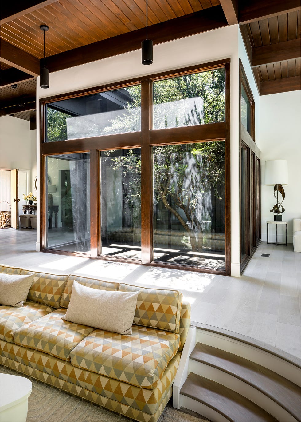 salón con doble altura y patio interior con jardín
