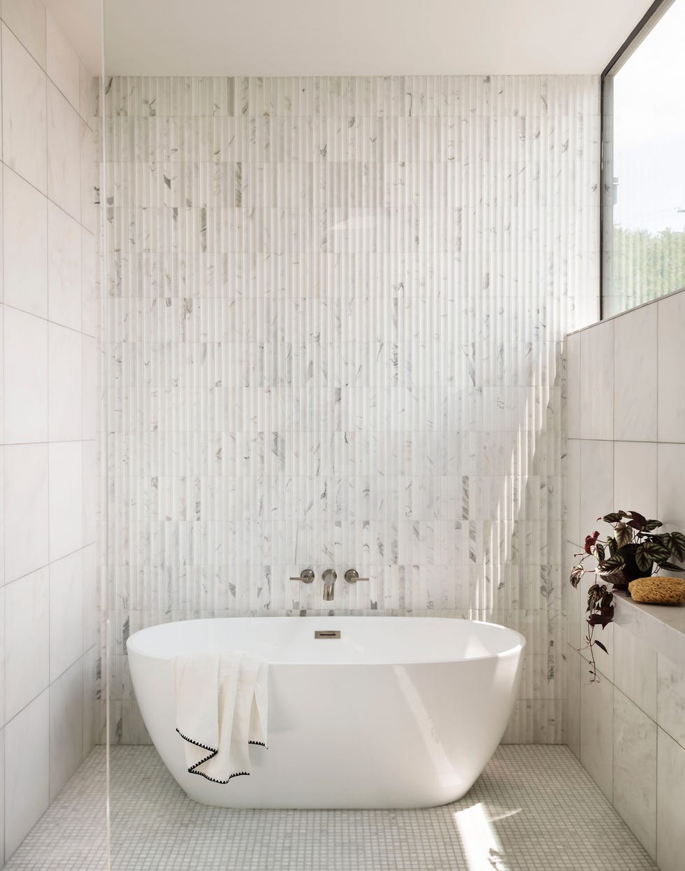 baño revestido en mármol con bañera exenta