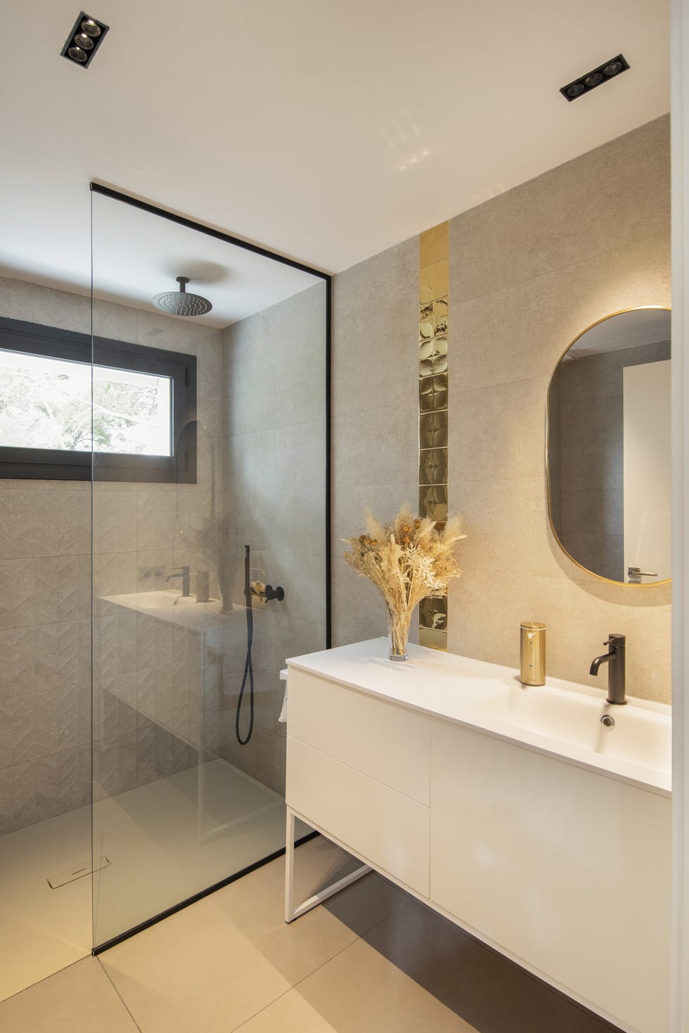 baño con ducha a ras de suelo y mueble de lavabo blanco